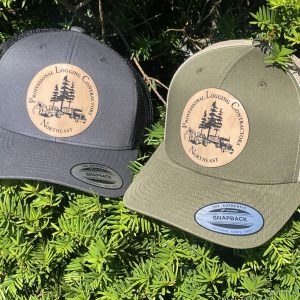 photo of two hats, one gray and one green, with the professional logging contractors of the northeast's logo on the front