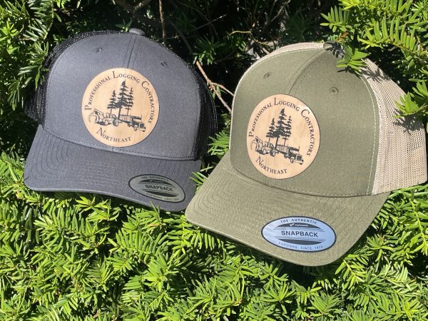 photo of two hats, one gray and one green, with the professional logging contractors of the northeast's logo on the front