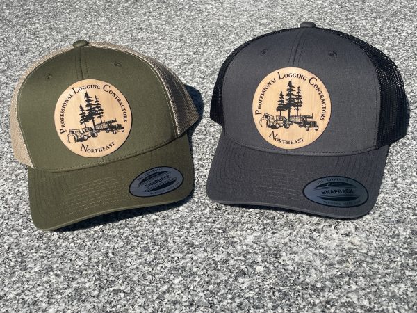 photo of two hats, one gray and one green, with the professional logging contractors of the northeast's logo on the front