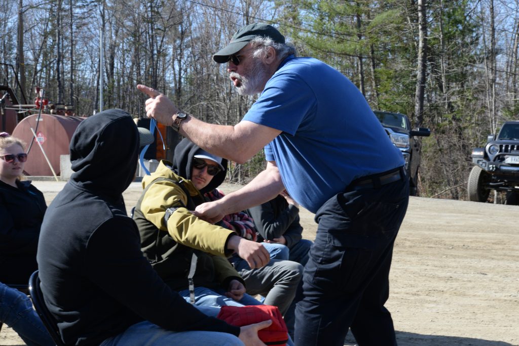 photo of a man holding another man's jacket by the arm and pointing off camera